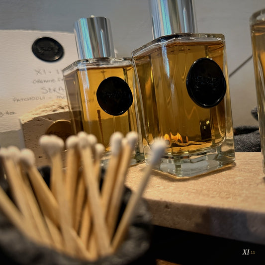 XI.11 Alba and Sera Parfum bottles displayed together with matte black candles and diffusers